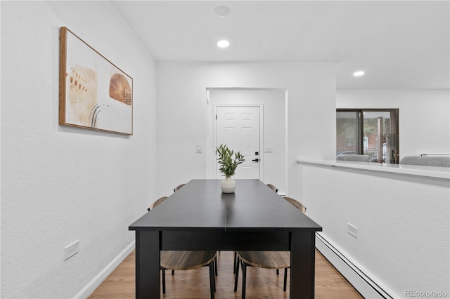 dining space featuring light hardwood / wood-style flooring and a baseboard heating unit