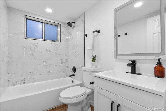 full bathroom featuring toilet, hardwood / wood-style floors, vanity, and tiled shower / bath combo