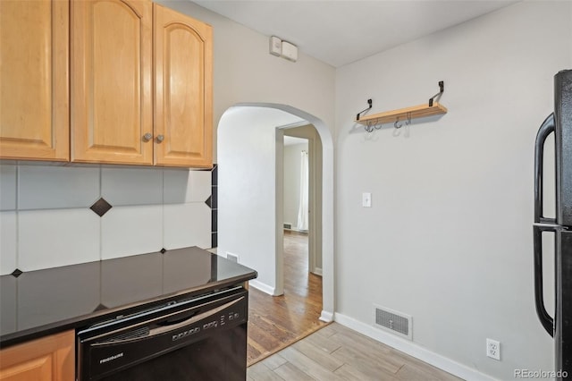 4072 Ames St, Wheat Ridge, CO 80212 - kitchen featuring black appliances, arched walkways, light wood-type flooring, dark countertops, and baseboards