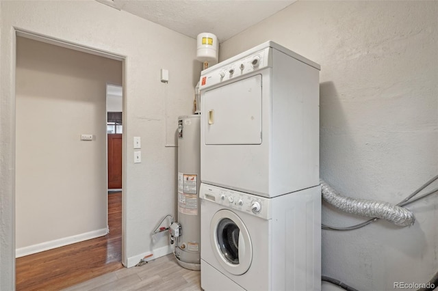 4072 Ames St, Wheat Ridge, CO 80212 - laundry room featuring stacked washer and clothes dryer, light wood-type flooring, gas water heater, and baseboards