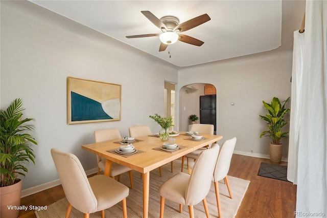 4072 Ames St, Wheat Ridge, CO 80212 - dining room featuring arched walkways, ceiling fan, baseboards, and light wood-type flooring