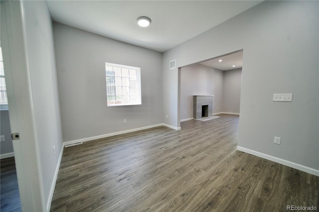 unfurnished living room with a fireplace and dark wood-type flooring