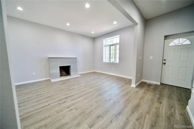 foyer entrance featuring a premium fireplace and light hardwood / wood-style flooring