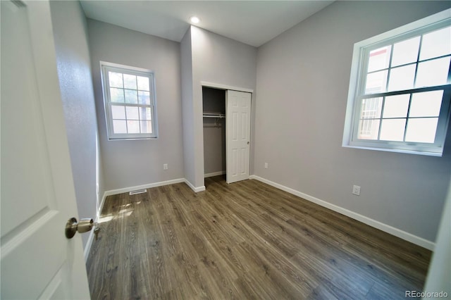 unfurnished bedroom featuring dark hardwood / wood-style floors and a closet