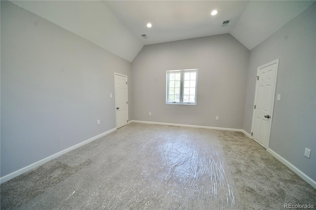 unfurnished room with lofted ceiling and light carpet