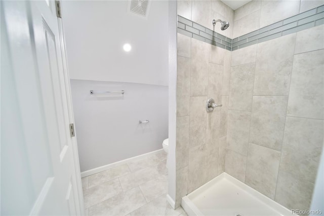 bathroom featuring toilet and a tile shower