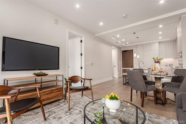 living area with recessed lighting, light wood-style flooring, and baseboards