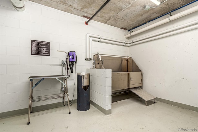 miscellaneous room featuring concrete floors and concrete block wall