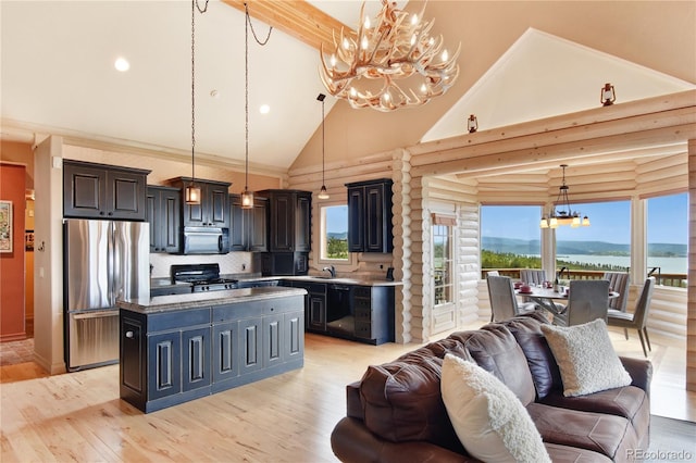 kitchen with decorative light fixtures, black appliances, light hardwood / wood-style floors, a center island, and high vaulted ceiling