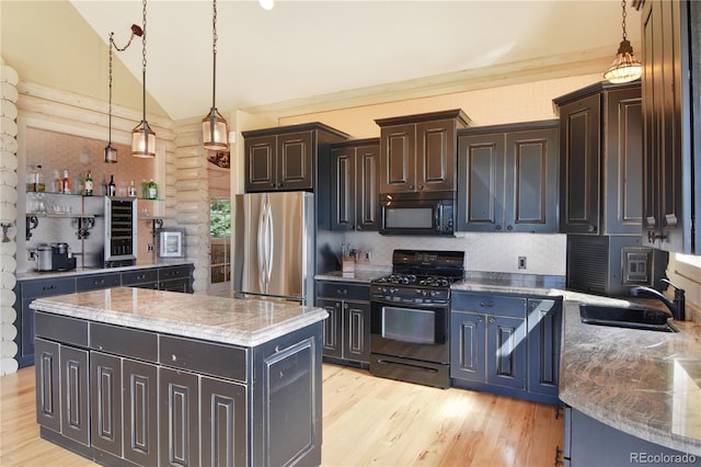 kitchen with vaulted ceiling, black appliances, light hardwood / wood-style flooring, a center island, and sink