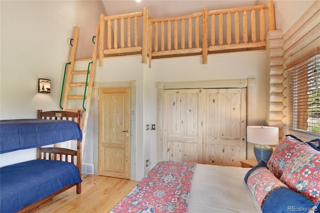 bedroom with a high ceiling and light hardwood / wood-style flooring