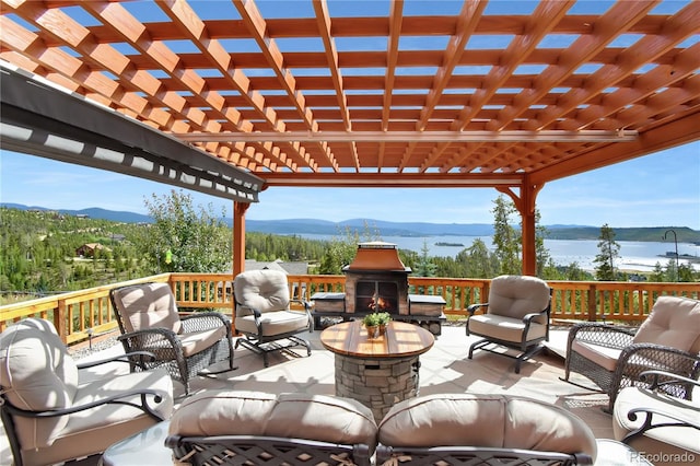 view of patio / terrace featuring a water and mountain view, a pergola, and outdoor lounge area