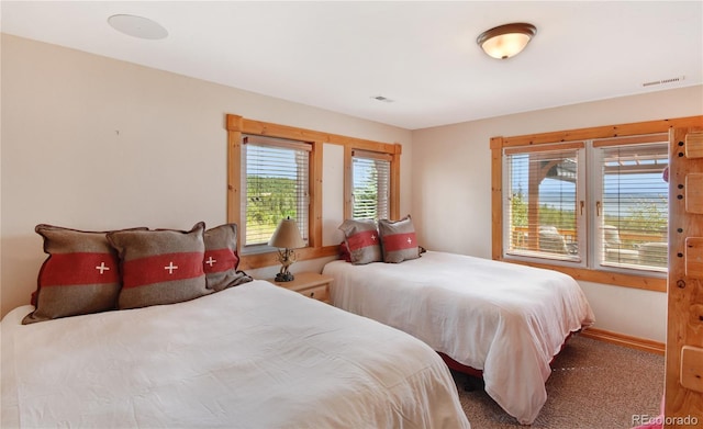 carpeted bedroom with visible vents and baseboards