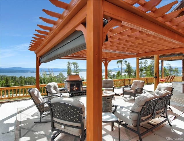 view of patio featuring a water and mountain view and an outdoor living space with a fireplace