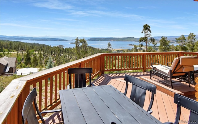 wooden terrace featuring a water and mountain view