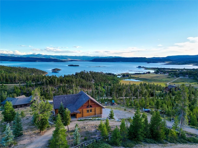 aerial view with a wooded view and a water and mountain view