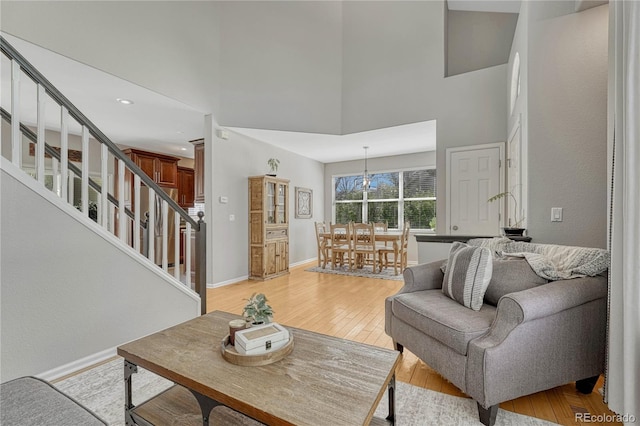 12646 S Dove Creek Way, Parker, CO 80134 - living area featuring stairway, light wood finished floors, a towering ceiling, and baseboards