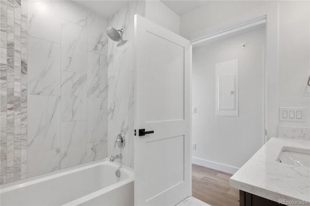 full bathroom with bathtub / shower combination, wood finished floors, vanity, baseboards, and electric panel