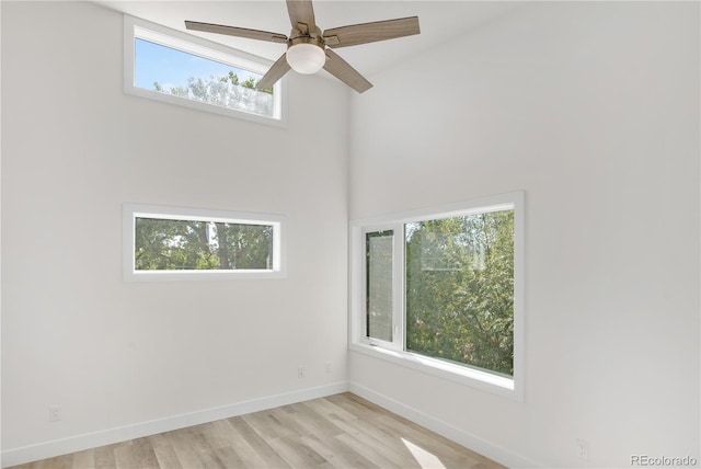 unfurnished room featuring a ceiling fan, light wood-style flooring, and baseboards