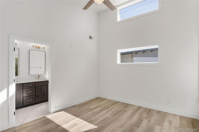 spare room featuring visible vents, ceiling fan, light wood-style flooring, and baseboards