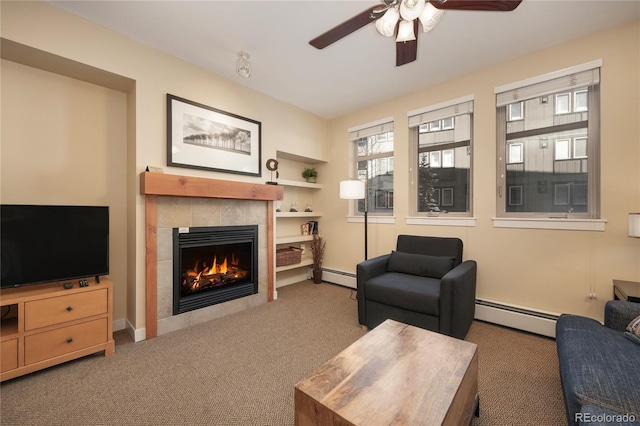 carpeted living room featuring ceiling fan, a baseboard radiator, and a tiled fireplace