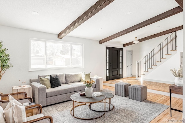 living room featuring beam ceiling and light wood-type flooring