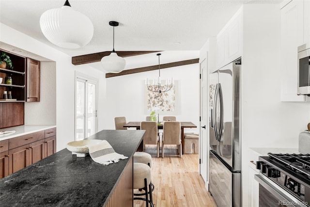 kitchen with light hardwood / wood-style floors, a kitchen breakfast bar, white cabinets, pendant lighting, and stainless steel appliances