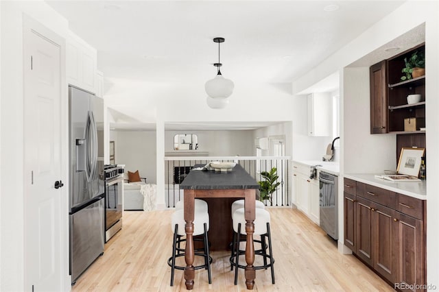 kitchen featuring white cabinetry, dark brown cabinetry, and stainless steel appliances