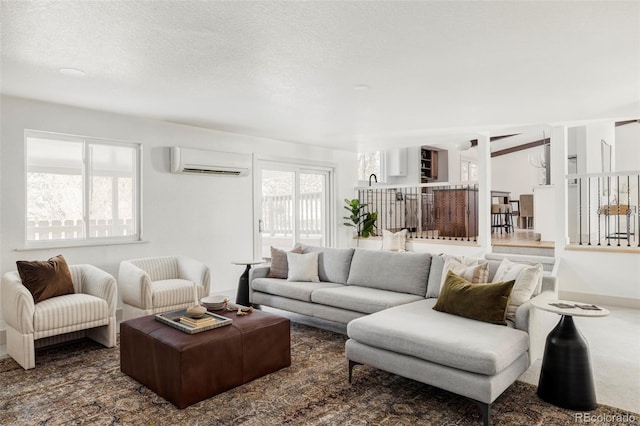 living room featuring carpet, an AC wall unit, and a textured ceiling