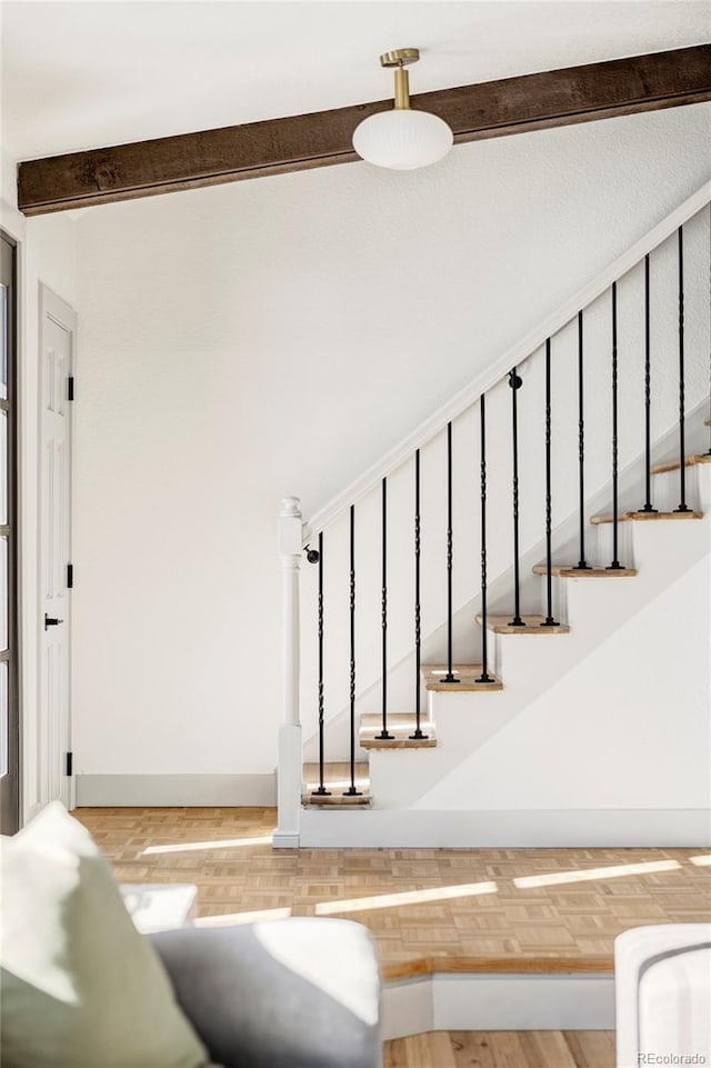 stairway with hardwood / wood-style flooring and beam ceiling