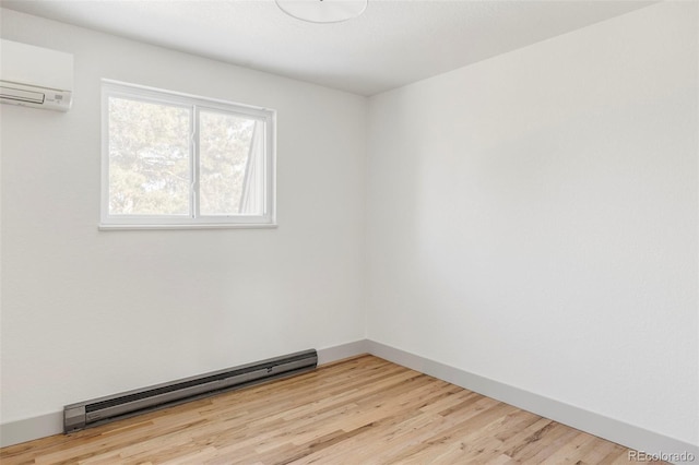 empty room with a wall mounted air conditioner, light hardwood / wood-style flooring, and a baseboard heating unit