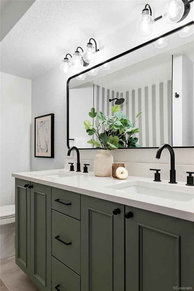 bathroom featuring toilet, a textured ceiling, and vanity