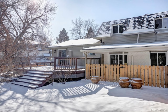 snow covered house featuring a deck