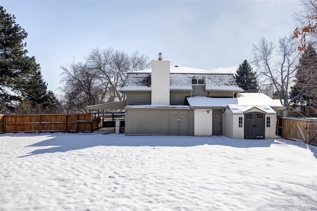 snow covered property featuring a shed