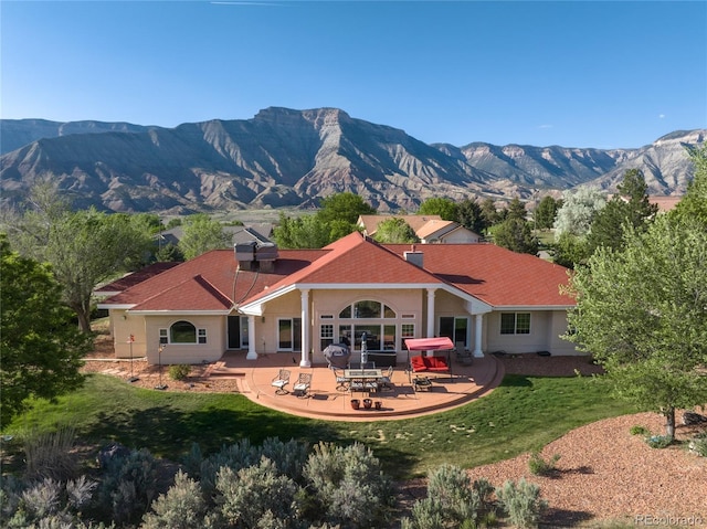 332 Battlement Creek Trl, Parachute, CO 81635 - back of house with a patio, a yard, and a mountain view