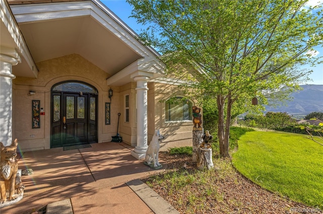 332 Battlement Creek Trl, Parachute, CO 81635 - property entrance featuring a mountain view, a lawn, and stucco siding