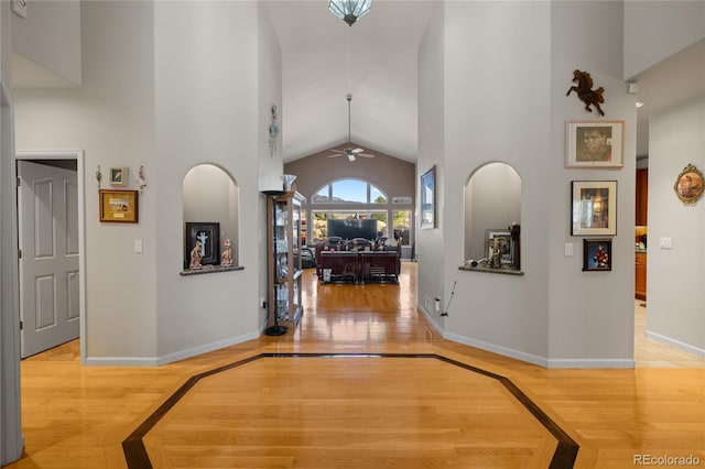 332 Battlement Creek Trl, Parachute, CO 81635 - hall featuring inlaid floor details, baseboards, light wood finished floors, and high vaulted ceiling