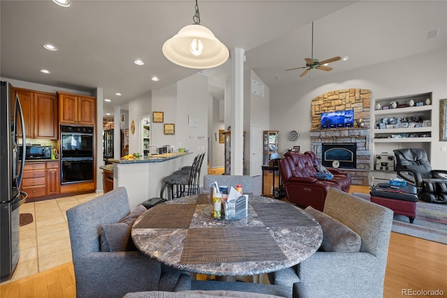 332 Battlement Creek Trl, Parachute, CO 81635 - dining area featuring a ceiling fan, a fireplace, recessed lighting, built in features, and light wood-style floors