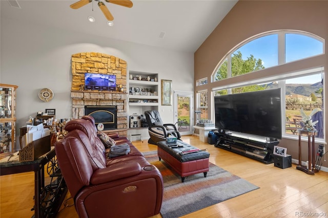 332 Battlement Creek Trl, Parachute, CO 81635 - living area featuring wood-type flooring, high vaulted ceiling, ceiling fan, and a stone fireplace