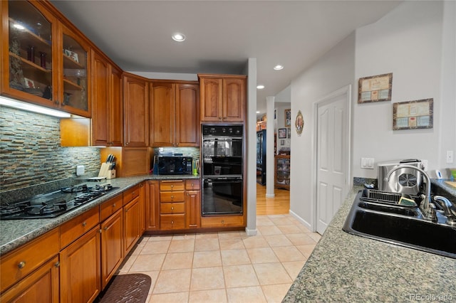 332 Battlement Creek Trl, Parachute, CO 81635 - kitchen with black appliances, a sink, light tile patterned floors, backsplash, and glass insert cabinets