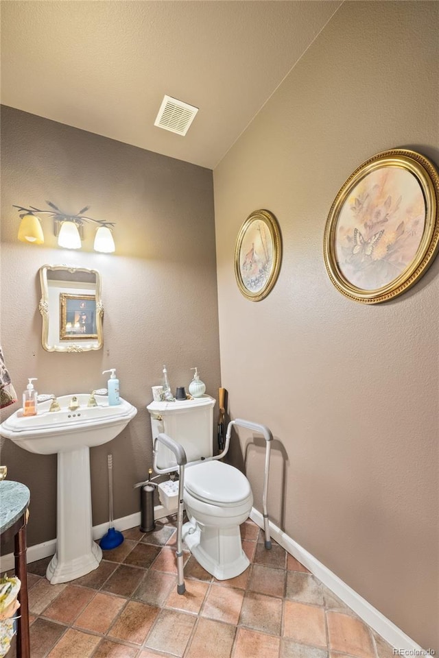 332 Battlement Creek Trl, Parachute, CO 81635 - bathroom featuring toilet, baseboards, and stone tile flooring