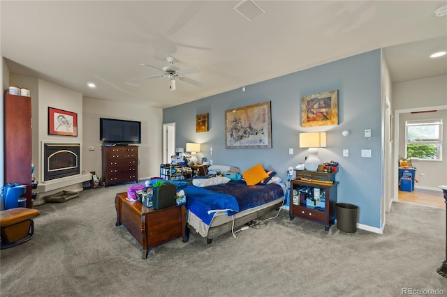 332 Battlement Creek Trl, Parachute, CO 81635 - bedroom with carpet flooring, baseboards, a glass covered fireplace, ceiling fan, and recessed lighting