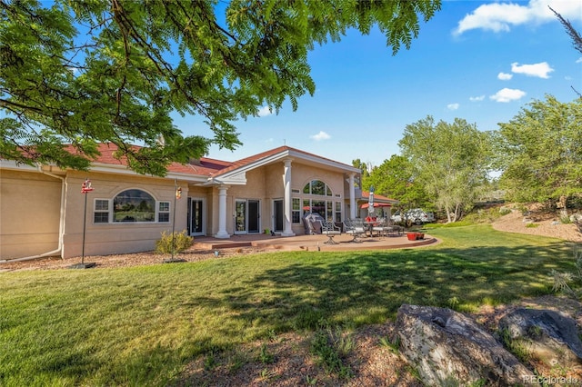 332 Battlement Creek Trl, Parachute, CO 81635 - back of property featuring a yard, stucco siding, and a patio