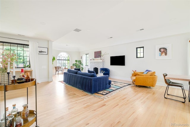 1300 N Glencoe St, Denver, CO 80220 - living area featuring light wood finished floors and a brick fireplace
