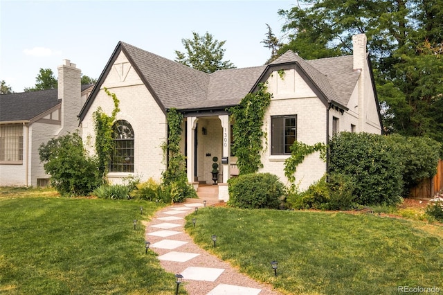 1300 N Glencoe St, Denver, CO 80220 - tudor house with a chimney, a front lawn, and brick siding