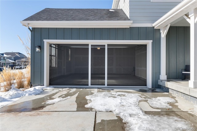 snow covered property entrance featuring a garage