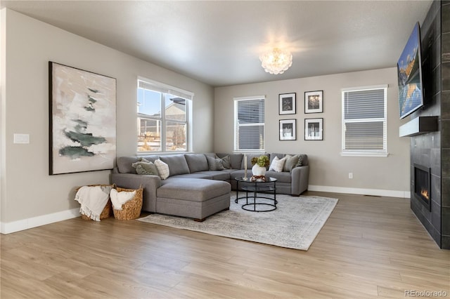 living room with an inviting chandelier, hardwood / wood-style floors, and a fireplace