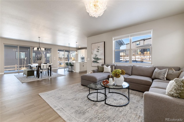 living room with a notable chandelier and light wood-type flooring