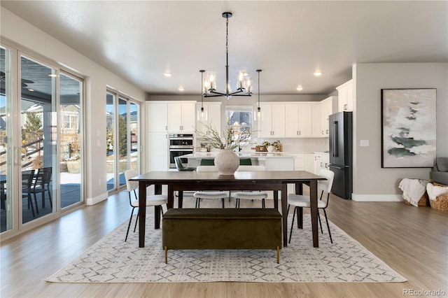 dining space featuring a notable chandelier and light hardwood / wood-style flooring