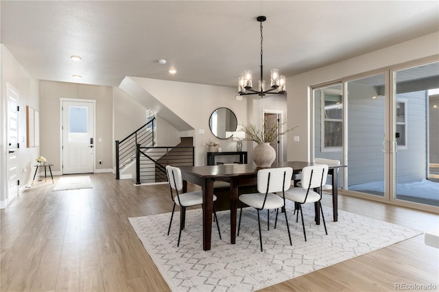 dining room with an inviting chandelier, a wealth of natural light, and light wood-type flooring